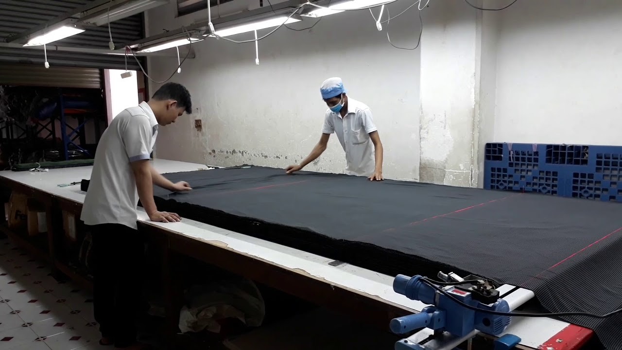 Nhân công tiến hành trải vải trước khi may áo đồng phục Hải Anh