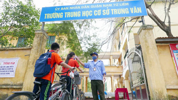 Sáng 4/5, học sinh THCS Trung Văn (Nam Từ Liêm) quay trở lại trường, đo thân nhiệt trước khi vào lớp.