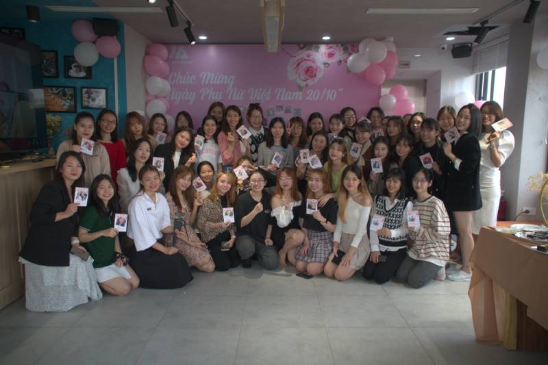 Hội chị em phụ nữ khối văn phòng tại Đồng phục Hải Anh rạng rỡ bên cạnh tấm thiệp chúc mừng