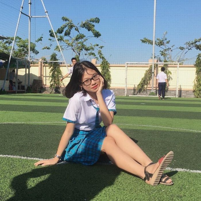 Trang phục là sự kết hợp giữa sơ mi trắng cùng váy xanh caro