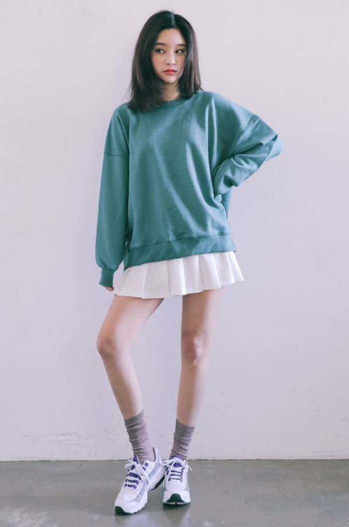 Váy ngắn kết hợp cùng áo thun oversize dài tay tạo phong cách thời trang cá tính