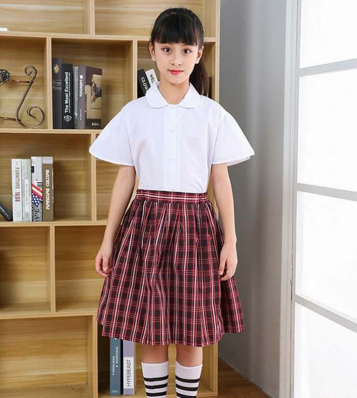 Hình ảnh học sinh tiểu học trong chiếc áo sơ mi trắng và váy hoạ tiết